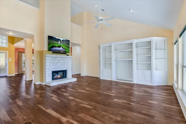 a view of empty room with wooden floor and fireplace