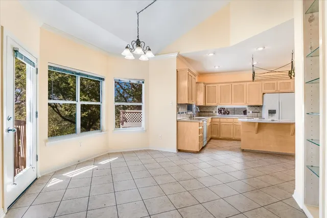 a view of a kitchen with granite countertop stainless steel appliances cabinets and a large window