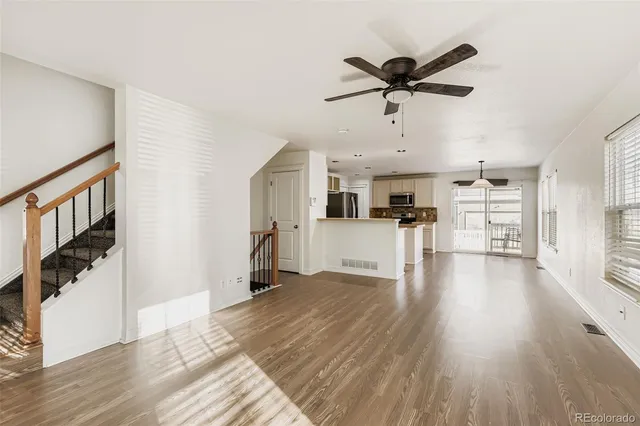 a view of a kitchen with wooden floor and a ceiling fan