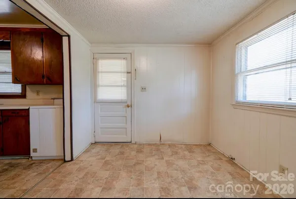 an empty room with windows and cabinet