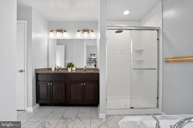 a bathroom with a glass door shower a sink and a mirror