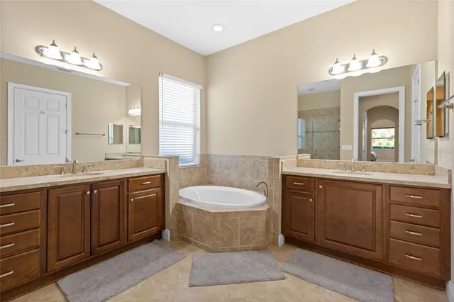 a spacious bathroom with a granite countertop tub sink and mirror