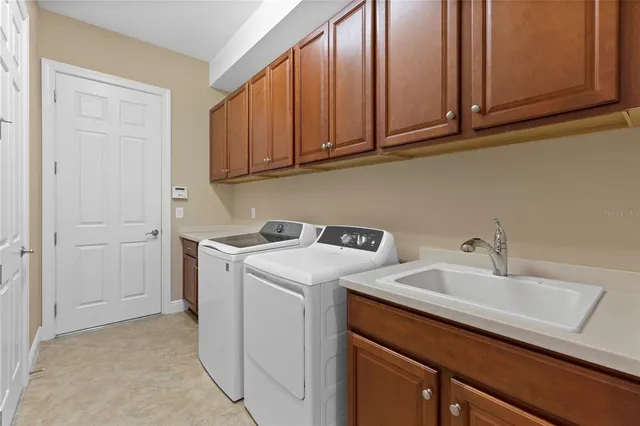 a utility room with sink dryer and washer