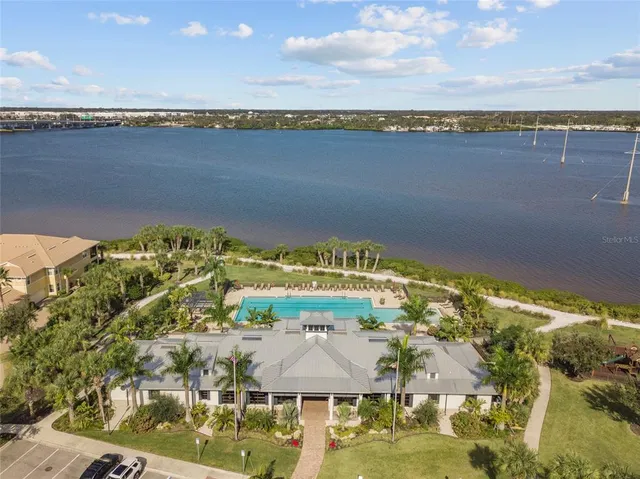a front view of a house with swimming pool lawn chairs and wooden floor