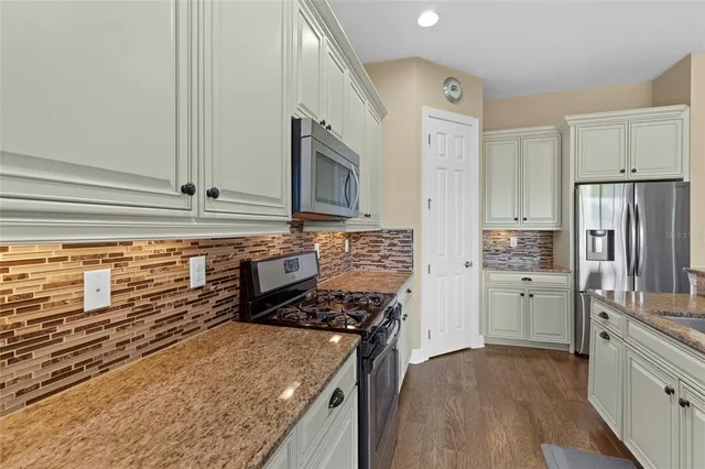 a kitchen with refrigerator cabinets and stove top oven