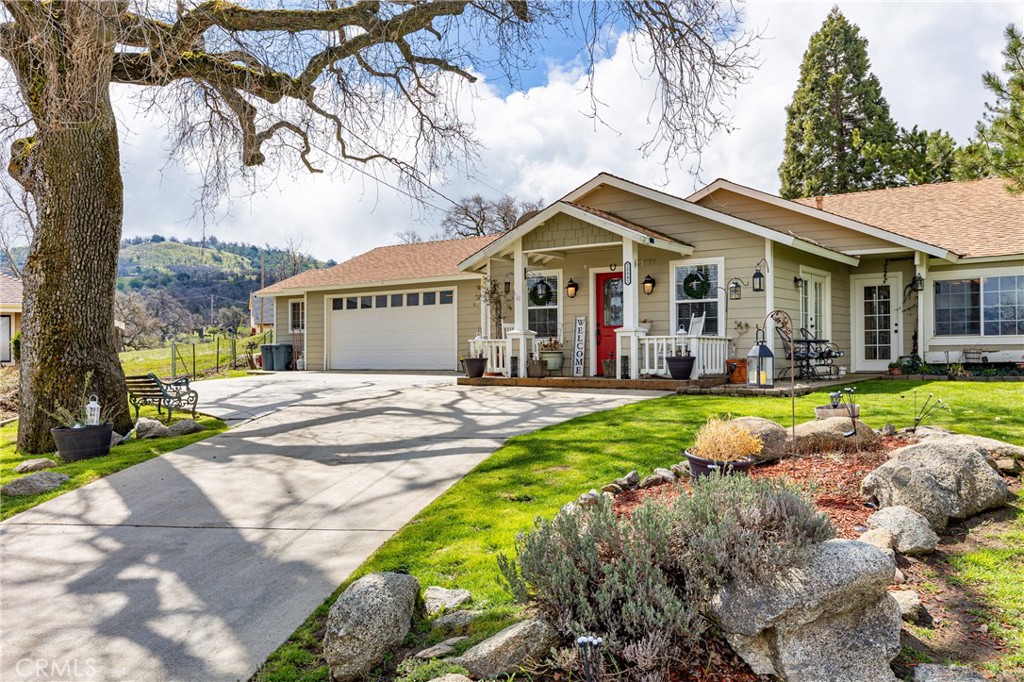 28841 Delaware Drive Tehachapi, CA 93561 - Photo 1 of 36 a view of a white house with a swimming pool and lawn chairs under an umbrella