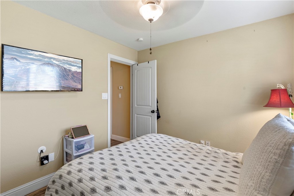 28841 Delaware Drive Tehachapi, CA 93561 - Photo 22 of 36 a bedroom with a bed and a chandelier