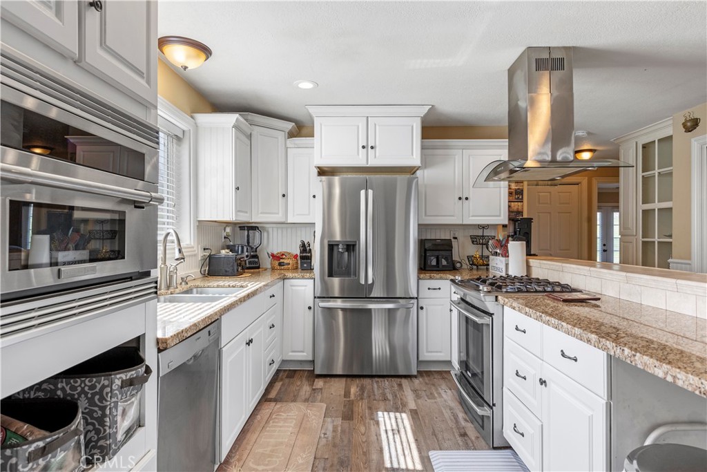 28841 Delaware Drive Tehachapi, CA 93561 - Photo 7 of 36 a kitchen with white cabinets and stainless steel appliances
