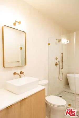 a bathroom with a granite countertop sink a toilet and a mirror