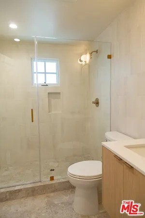 a bathroom with a toilet a sink and shower