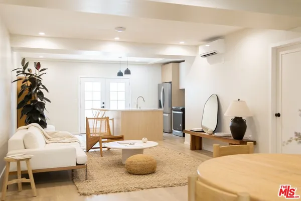 a living room with furniture a mirror and gym equipment