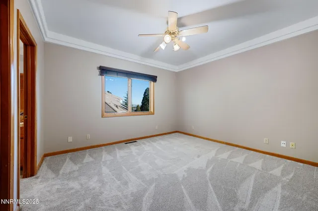 an empty room with closet and a ceiling fan