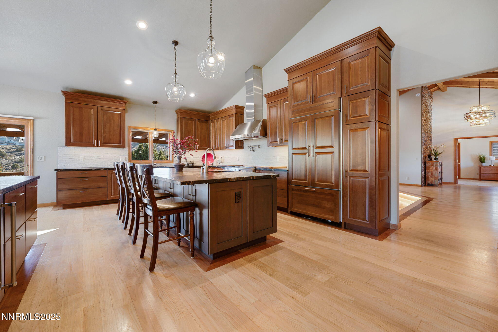1205 Greensburg Circle Reno, NV 89509 - Photo 9 of 41 a kitchen with stainless steel appliances kitchen island granite countertop a refrigerator a stove a sink a dining table and chairs with wooden floor