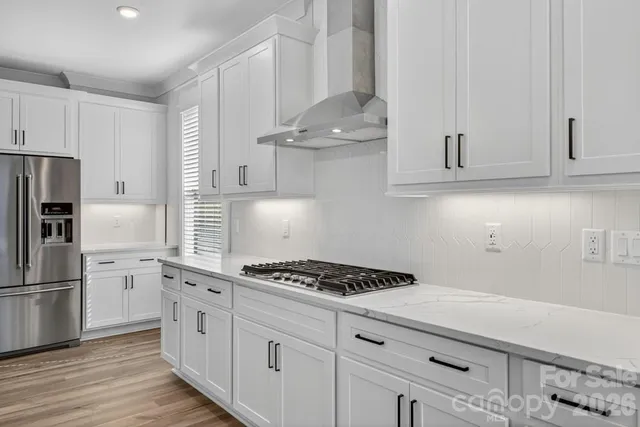 a kitchen with stainless steel appliances kitchen island a white stove top oven and cabinets