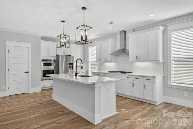 a kitchen with white cabinets and appliances