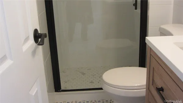 a white toilet sitting next to a shower