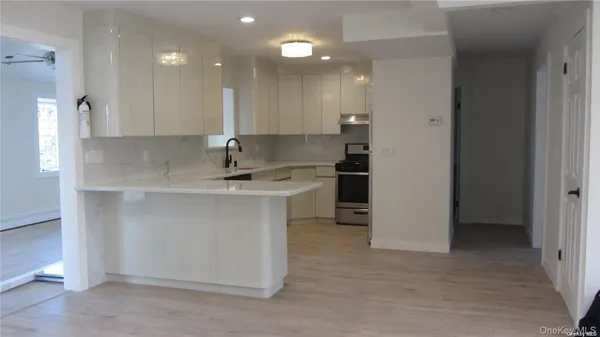 a kitchen with kitchen island a sink stainless steel appliances and cabinets