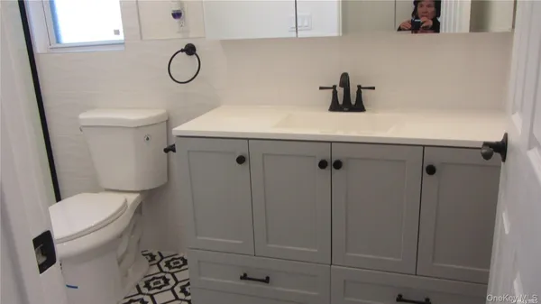 a bathroom with a toilet a sink and a mirror