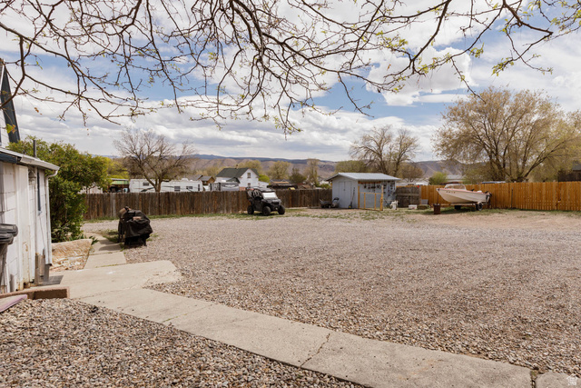 197 West 100 South Redmond, UT 84652 - Photo 22 of 41 Fenced backyard with a storage shed and a residential view
