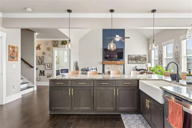 a kitchen with a sink stove and wooden floor