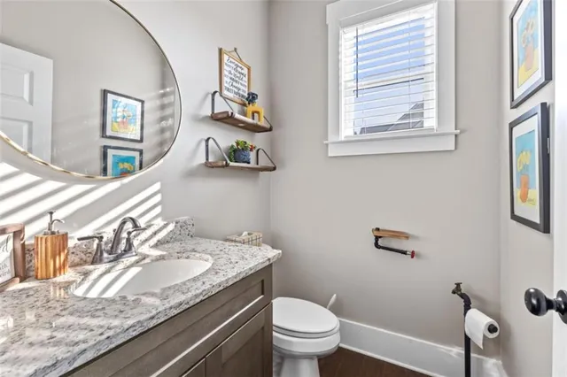a bathroom with a granite countertop sink mirror and toilet