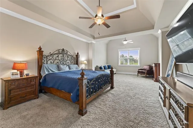 a bedroom with a bed a chandelier and dresser