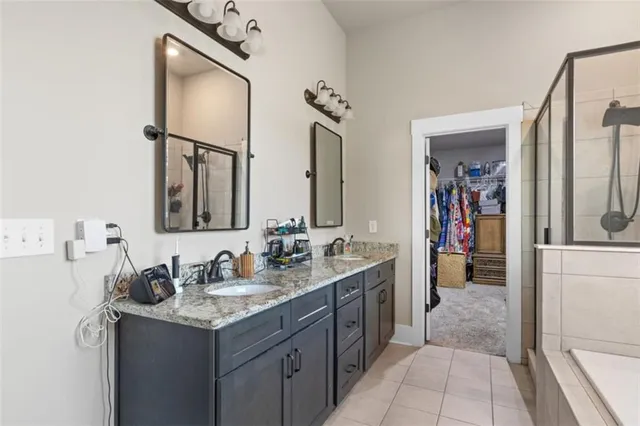 a en suite bathroom with a granite countertop sink and a mirror