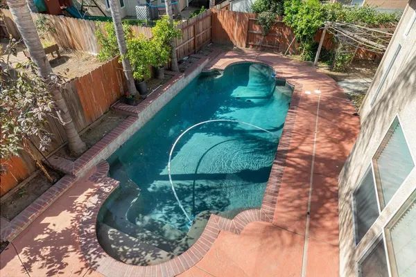 a backyard of a house with table and chairs and potted plants