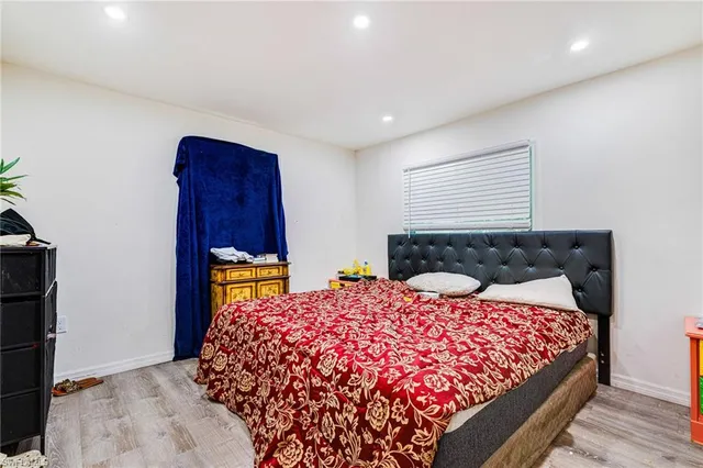 a bed sitting in a bedroom next to a window with wooden floor
