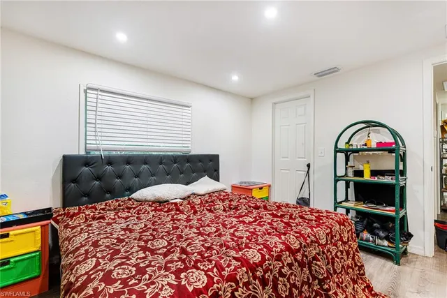 a bedroom with a bed a dresser and a book shelf