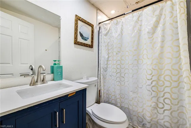 a bathroom with a sink a toilet and shower curtain
