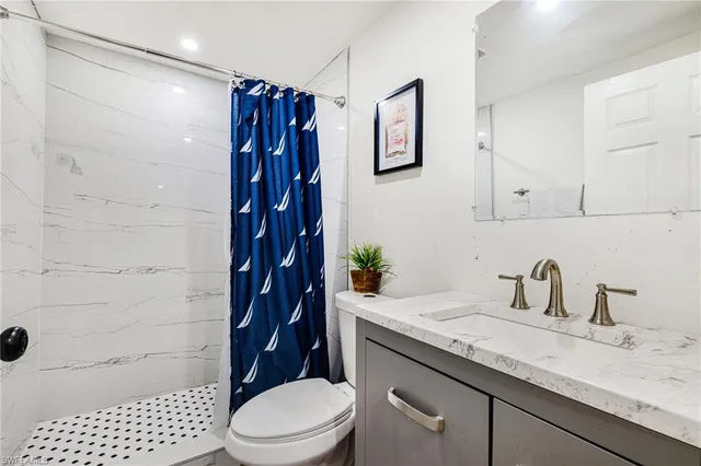 a bathroom with a granite countertop sink toilet and shower