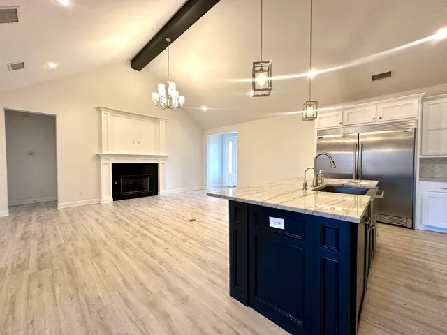 a kitchen with kitchen island granite countertop a sink appliances and cabinets