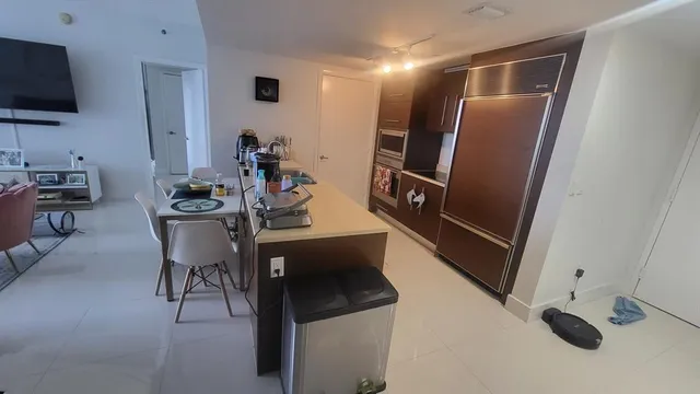 a kitchen with stainless steel appliances wooden floor and chairs