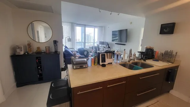 a kitchen with a sink and a stove with wooden floor