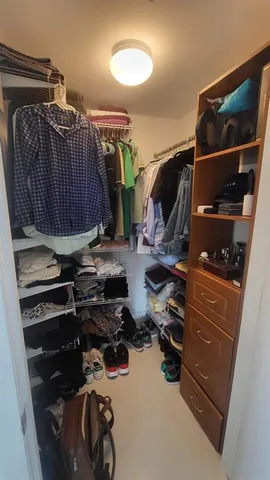 a view of walk in closet with clothes and shoes