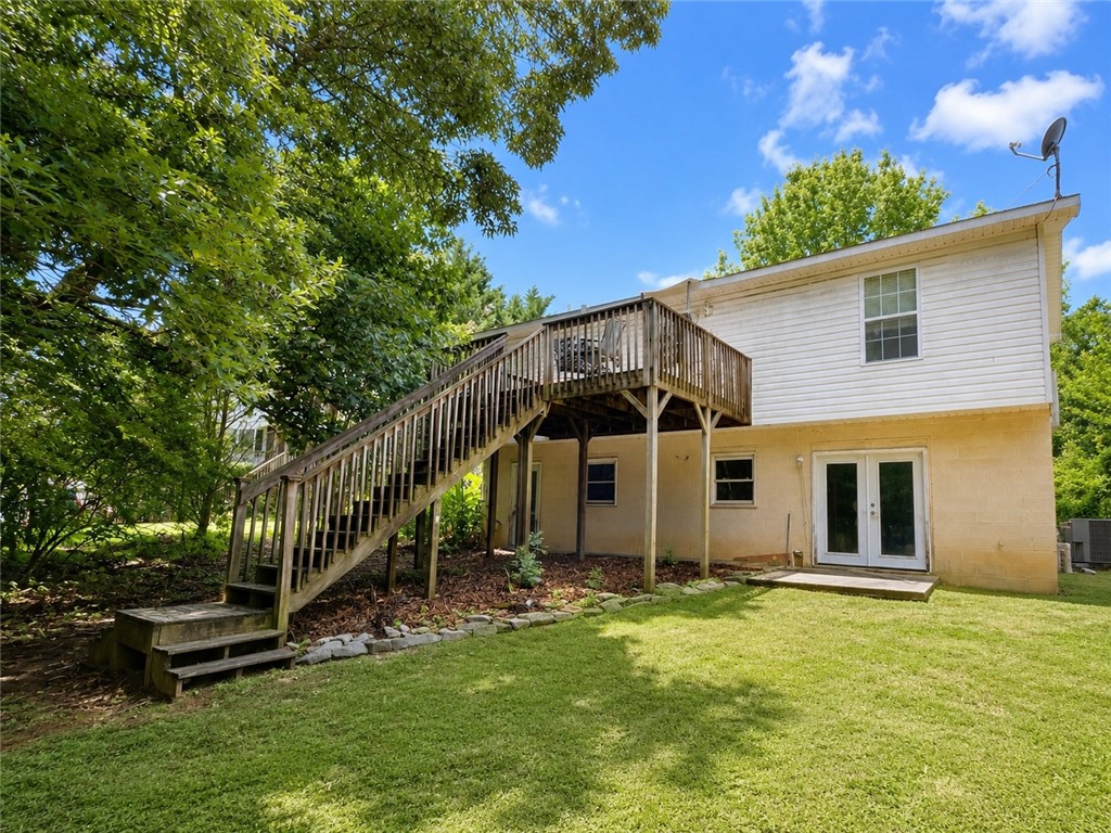 138 Cloverdale Road Seneca, SC 29678 - Photo 5 of 27 A broad elevated wooden deck offers a pleasant outdoor retreat, overlooking a manicured lawn.