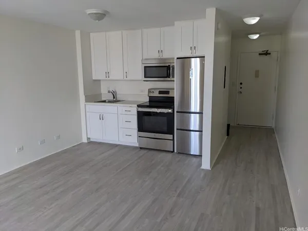 a kitchen with granite countertop a refrigerator and a stove top oven