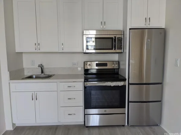 a kitchen with white cabinets and stainless steel appliances