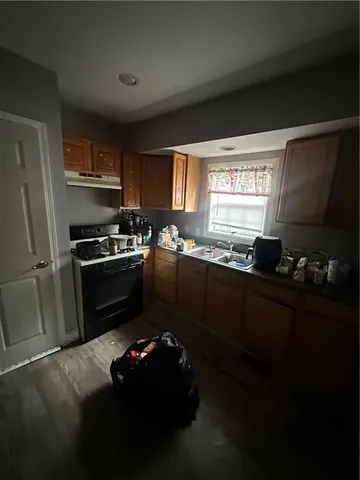 a kitchen with granite countertop stainless steel appliances a sink stove and refrigerator