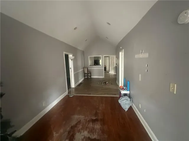 a view of a hallway with wooden floor and a living room