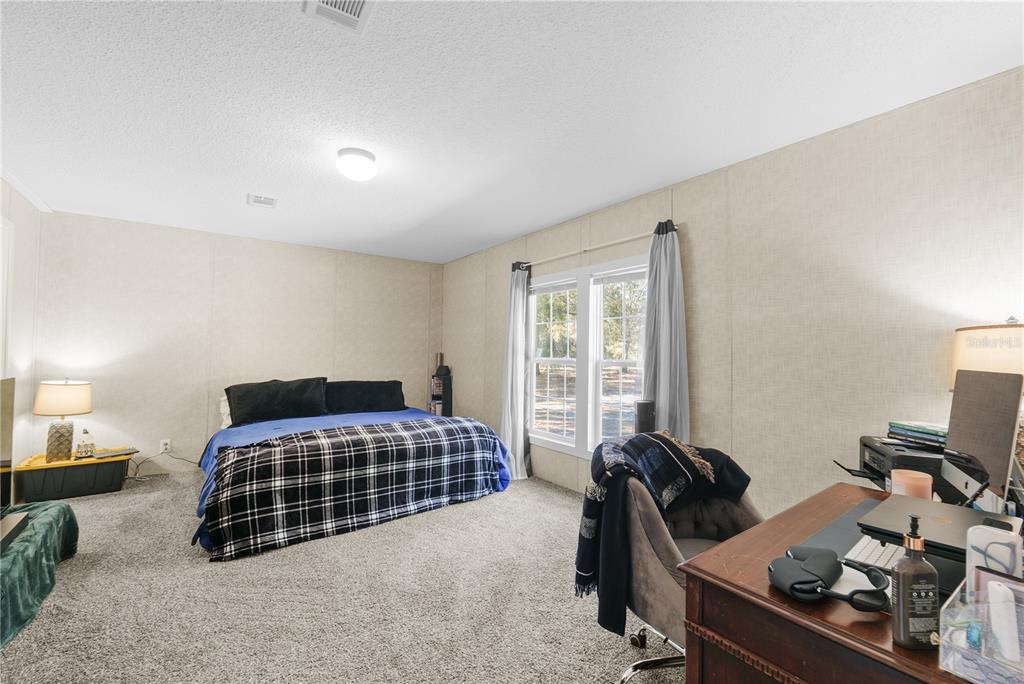 18625 Deason Drive Spring Hill, FL 34610 - Photo 13 of 35 a bedroom with a bed and a window