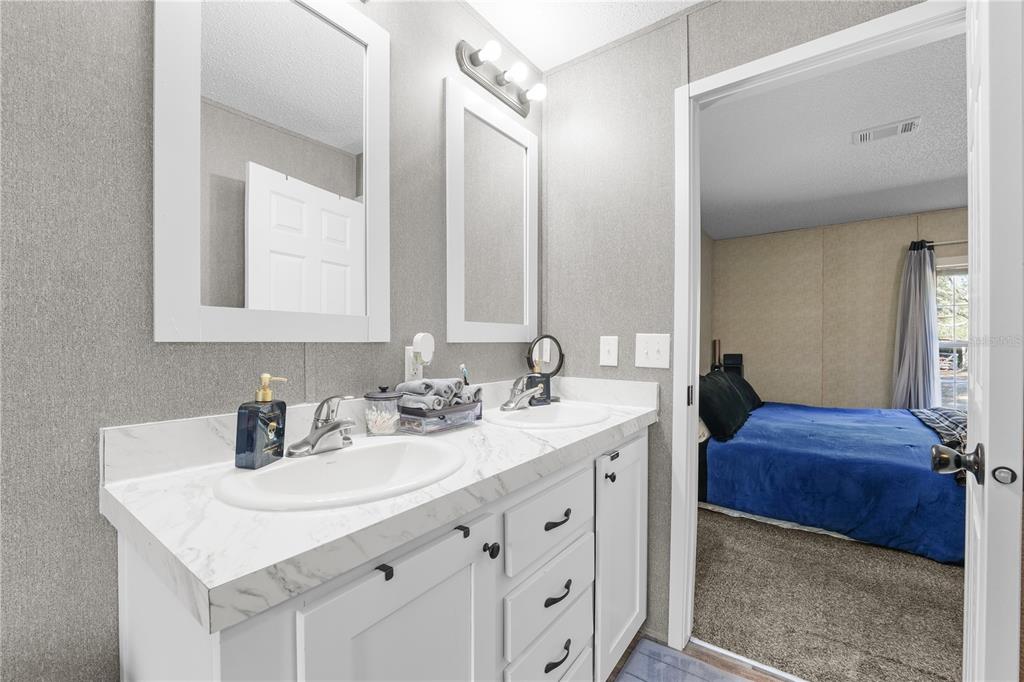18625 Deason Drive Spring Hill, FL 34610 - Photo 16 of 35 a en suite bathroom with a double vanity sink and a mirror