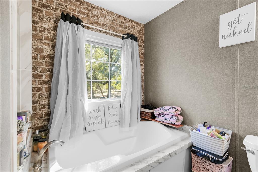 18625 Deason Drive Spring Hill, FL 34610 - Photo 17 of 35 a bathroom with a tub sink and a window