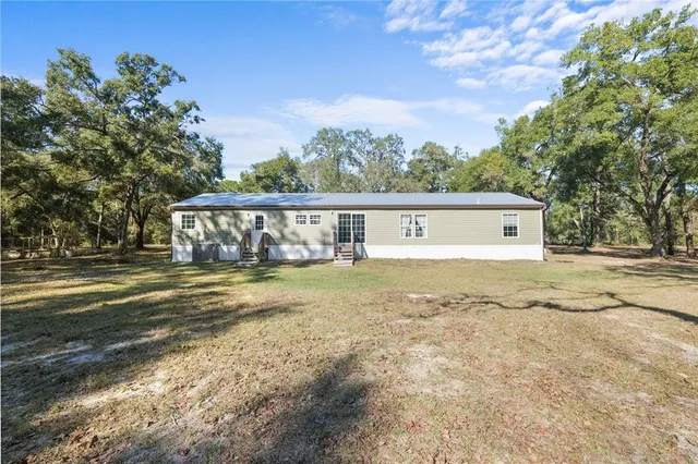 a front view of house with yard and trees