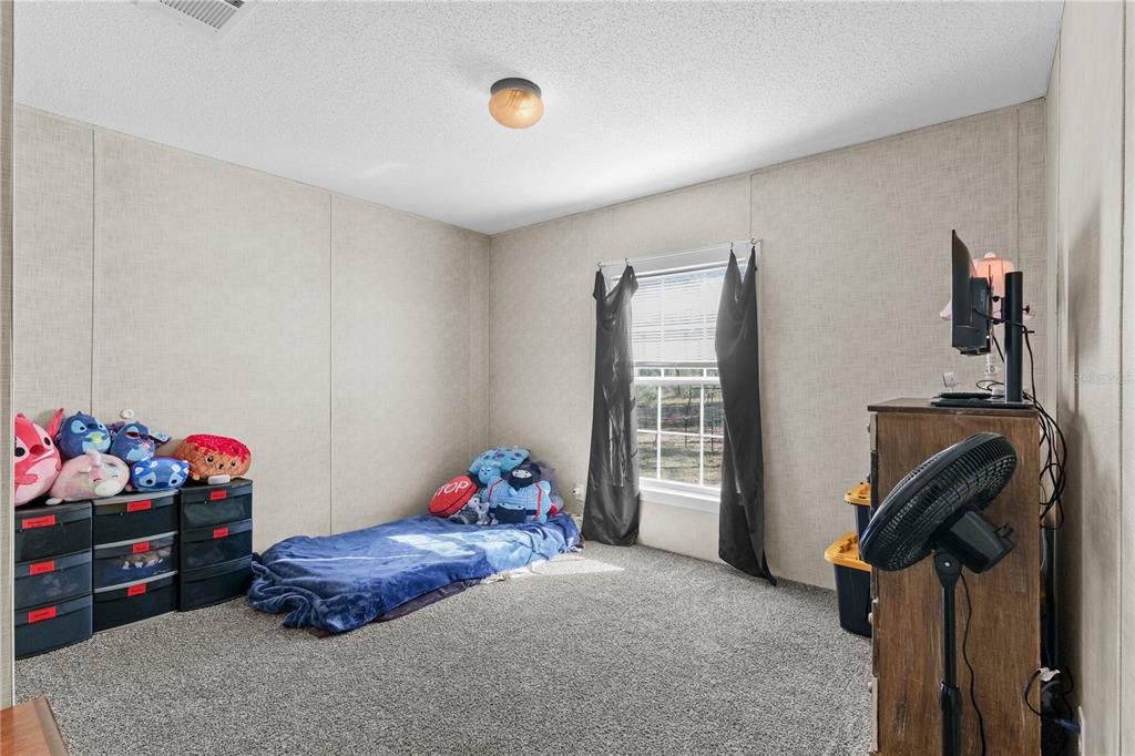 18625 Deason Drive Spring Hill, FL 34610 - Photo 26 of 35 a bedroom with a bed and a window