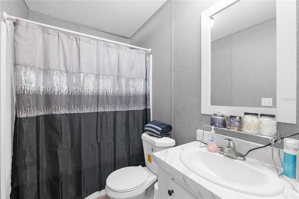 18625 Deason Drive Spring Hill, FL 34610 - Photo 27 of 35 a bathroom with a sink a toilet and shower