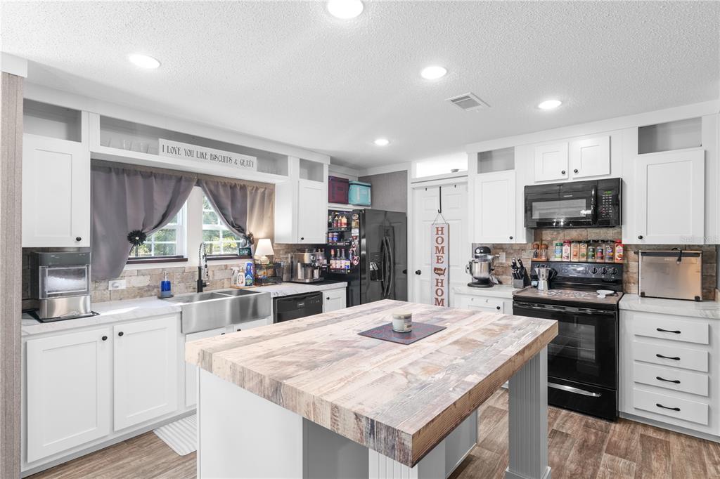 18625 Deason Drive Spring Hill, FL 34610 - Photo 8 of 35 a kitchen with kitchen island a sink counter top space appliances and cabinets