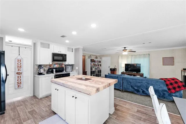 a kitchen with a sink a counter top space stainless steel appliances and cabinets
