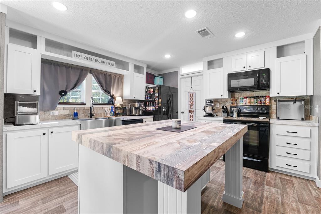 18625 Deason Drive Spring Hill, FL 34610 - Photo 10 of 35 a kitchen with a stove a sink a microwave a refrigerator and cabinets